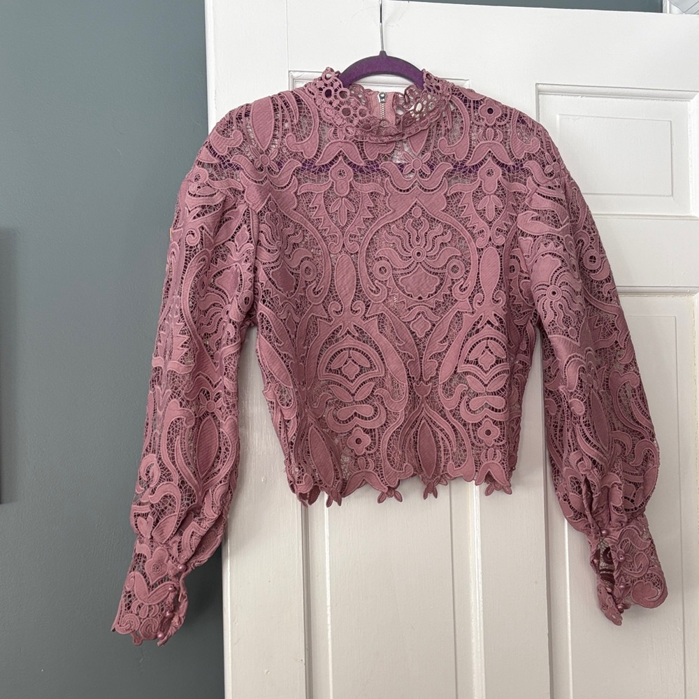 Stunning lace top with back zipper, long sleeves and button cuffs.